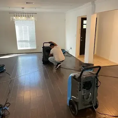 Technician setting up a dehumidifier during a water damage dry-out