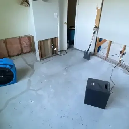 Technician measuring moisture in a wall with a handheld meter after a leak