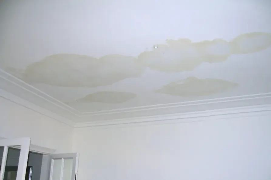 Ceiling stain spreading under an overflowing air conditioner drain pan