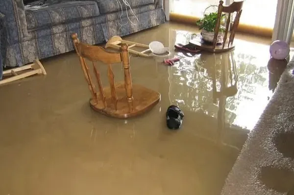 Muddy floodwater covering a living room floor